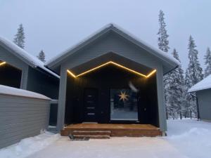 una casa con luces en la parte delantera de ella en la nieve en Villa Anilia, en Syöte 12 fotos más