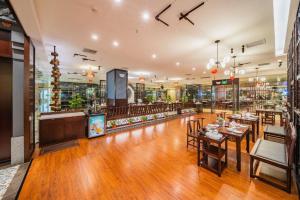 a restaurant with wooden floors and tables and chairs at Changsha Xiaoxiang Huatian Hotel in Changsha