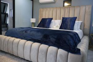 De Rams boutique guest house : غرفة نوم بسرير كبير مع وسائد زرقاء