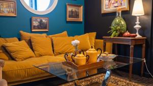 Hôtel Kyriad Brive Ouest في بريف لا غايلارد: غرفة معيشة مع أريكة صفراء وطاولة زجاجية +34 صورة