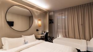 a hotel room with two beds and a mirror at Hôtel Kyriad Brive Ouest in Brive-la-Gaillarde