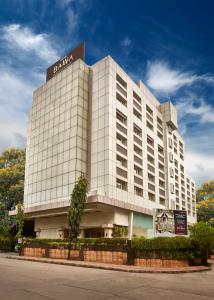 un gran edificio blanco con un cartel. en Hotel Bawa International en Bombay