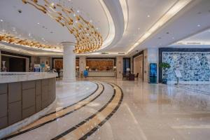 a large lobby with a chandelier in a building at Hangzhou Huachen Fengting Hotel in Hangzhou +233 photos