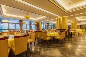 a restaurant with yellow tables and chairs in a room at Hangzhou Huachen Fengting Hotel in Hangzhou