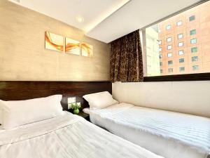 Un pat sau paturi într-o cameră la Noble Park Hotel