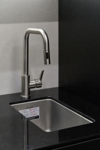 un fregadero de acero inoxidable en una cocina negra en Cov Stay Haeundae, en Busan 47 fotos más