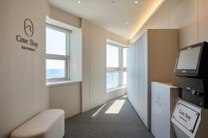 Una habitación con TV de pantalla plana y una sala de espera. en Cov Stay Haeundae, en Busan