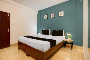 Collection O KIIT Square Bhubaneswar Formerly Nilay Classic في Bārang: غرفة نوم بسرير كبير وجدار أزرق +50 صورة