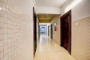 Collection O KIIT Square Bhubaneswar Formerly Nilay Classic في Bārang: ممر فارغ في مبنى به باب وجدران من البلاط