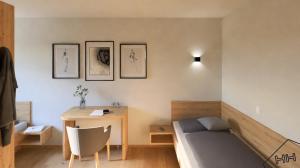 Pension Reiterhaus في واغراين: غرفة نوم بها سرير ومكتب وطاولة