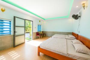 een slaapkamer met een bed en een glazen schuifdeur bij ML Homestay in Binh Chau