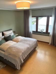a bedroom with a large bed and a window at Antweiler Ferienwohnung in Bleialf