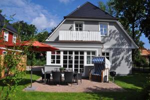 a white house with a table and chairs in the yard at Bebelstr 11 in Prerow