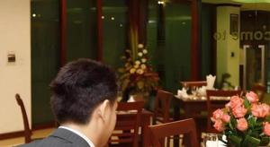 Lao Golden Hotel في Ban That-Louang: رجل يجلس على طاولة في مطعم