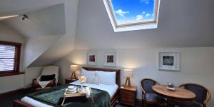 Sandstone Suites - In the heart of Port Fairy في بور فيري: غرفة نوم بها سرير وطاولة ونافذة