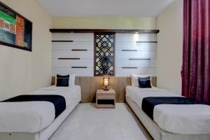 a bedroom with two beds and a window at Collection O near Stadion Manahan formerly Graha Laweyan Solo in Bonorejo