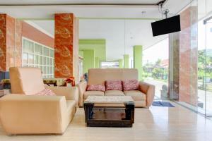 a living room with two chairs and a coffee table at Collection O near Stadion Manahan formerly Graha Laweyan Solo in Bonorejo