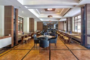 a dining room with long tables and chairs at Townhouse Kakinada Nagamalli Thota Junction in Kākināda
