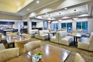 Hilton Garden Inn Chesapeake Greenbrier في تشيسابيك: مطعم به طاولات وكراسي وكافتيريا