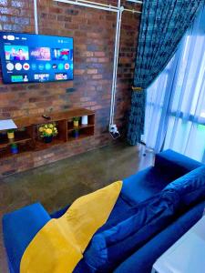 a living room with a blue couch and a flat screen tv at Craftsmanship 340 IMD in Johannesburg