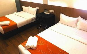 a hotel room with two beds and a table at Place2Stay @ The Mines in Serdang