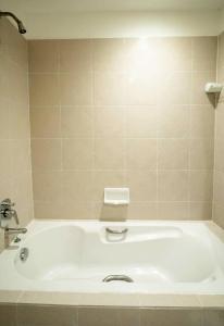 a bath tub in a bathroom with a sink at Jansom Beach Resort in Ranong