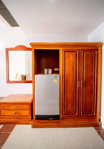 a kitchen with a white refrigerator and wooden cabinets at Jansom Beach Resort in Ranong