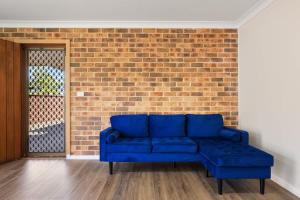 een blauwe bank voor een stenen muur bij Aqua on Achilles in Nelson Bay