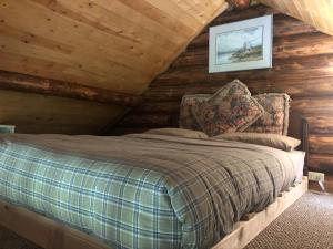 a bedroom with a bed in a log cabin at Cozy Log Cabin In Pristine Nature in Nelson