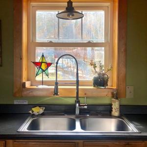 a kitchen sink and a window with a star on it at Cozy Log Cabin In Pristine Nature in Nelson