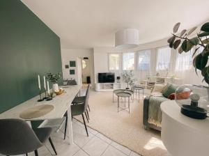 un soggiorno con divano e sala da pranzo di Le Sky - Penthouse de Standing Hyper-Centre Orsay Paris Saclay a Orsay