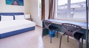 a bedroom with a bed and a desk and a window at Station Hotel Klang in Klang