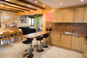 a kitchen with a wooden table and a dining room at Maison A Colombage De 1602 in Wintzenheim
