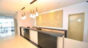 a living room with a long counter with a map on the wall at Hotel Puri 36 in Inanam