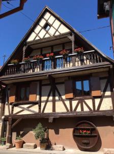 a building with flowers on the balconies of it at Maison A Colombage De 1602 in Wintzenheim