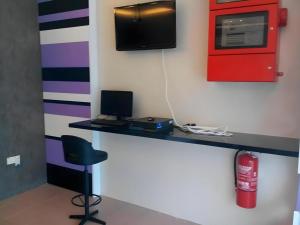 a room with a desk with a tv and a chair at RST Hotel in Sinkang Village