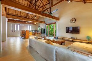 a living room with a couch and a tv at Villa Trembesi - New Spacious Luxury 2BR Private Villa - Free Gym Access - 60Mbps WiFi in Kuta Lombok