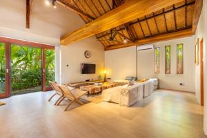 a living room with a couch and a table at Villa Trembesi - New Spacious Luxury 2BR Private Villa - Free Gym Access - 60Mbps WiFi in Kuta Lombok
