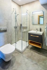 a bathroom with a shower and a toilet and a sink at Apartament Widokowy Karpacz z garażem i widokiem na góry, blisko szlaki i centrum in Karpacz