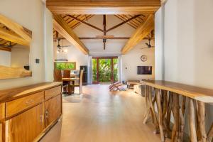 Villa Trembesi في كوتا لومبوك: مطبخ مفتوح ذو عوارض خشبية وغرفة طعام