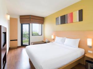 a bedroom with a white bed and white walls at Ibis Hua Hin - SHA Plus in Hua Hin