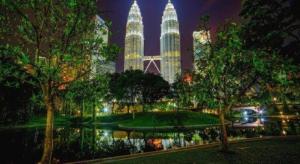 Un parque con dos torres altas por la noche. en The Hulo Hotel & Gallery, en Kuala Lumpur