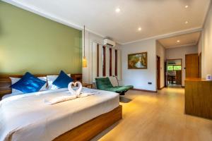 a bedroom with a large white bed with blue pillows at Villa Trembesi - New Spacious Luxury 2BR Private Villa - Free Gym Access - 60Mbps WiFi in Kuta Lombok +35 photos
