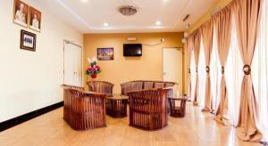 OYO 11343 Hotel Putra Iskandar في سيري إسكندر: غرفة بها أربعة كراسي وطاولة وستائر