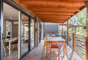 une terrasse en bois avec une table et des chaises dessus dans l'établissement Camping Village Costa Est, à Riotorto