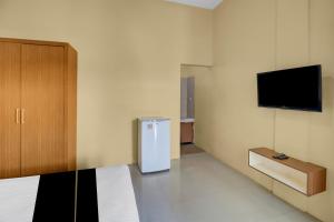 a room with a refrigerator and a tv on the wall at Hotel O near Trans Studio Theme Park formerly Cyloam Residence in Legian +21 photos