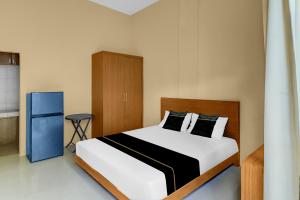 a bedroom with a bed and a blue cabinet at Hotel O near Trans Studio Theme Park formerly Cyloam Residence in Legian