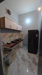 eine Küche mit einer Theke und einem schwarzen Kühlschrank in der Unterkunft Deoghar BnB in Deoghar