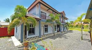a house with a lot of trees in front of it at OYO 90507 Chalet Sumayyah in Melaka