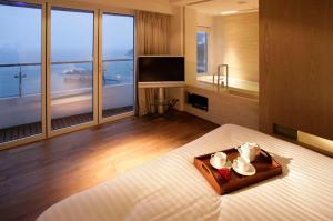 Una habitación de hotel con una cama con una bandeja de comida. en Stanley Oriental Hotel, en Hong Kong